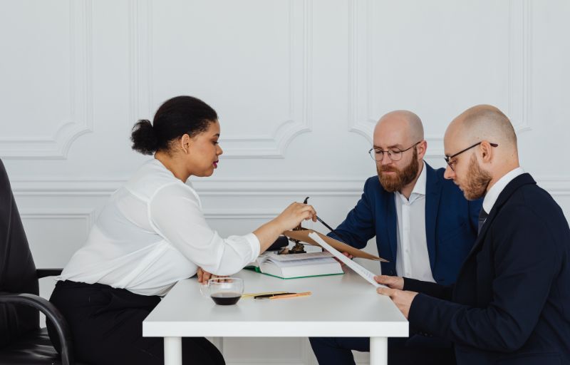 Healthcare RCM consultation meeting with medical billing experts reviewing documents for physician revenue cycle management and outsourcing services